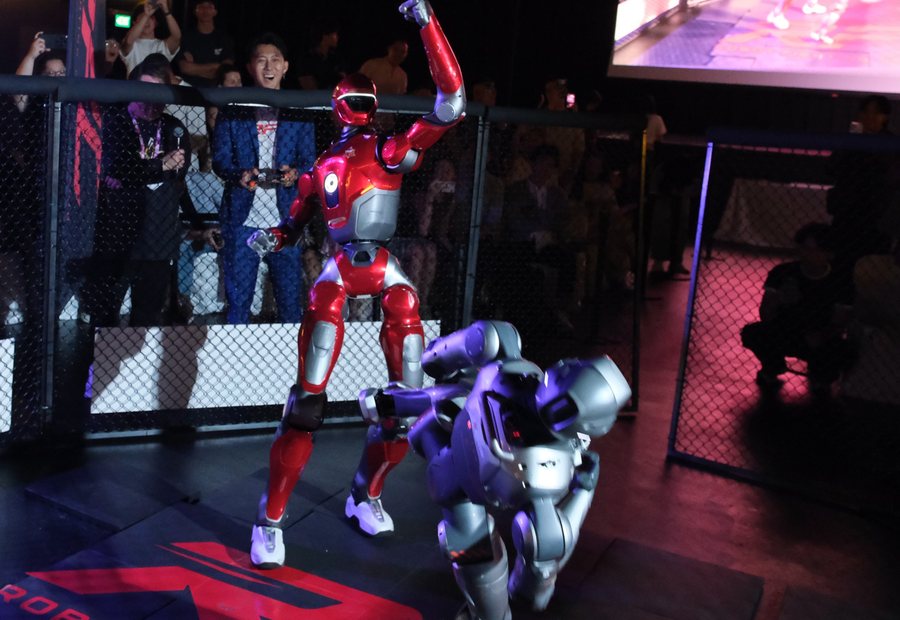 Red RFC robot raising a fist over a downed opponent